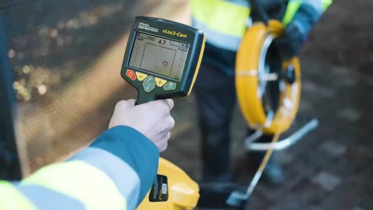 Technicien MS FIBRE relevant la position d'un fourreau au détecteur, sonde d'aiguillage à la main
